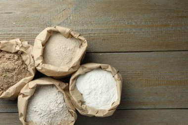 Tahta masadaki kağıt torbalarda farklı türde un var. Metin için boşluk