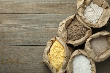 Tahta masadaki kağıt torbalarda farklı türde un var. Metin için boşluk