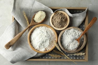 Açık gri masa üzerinde farklı un türleri, üst görünüm