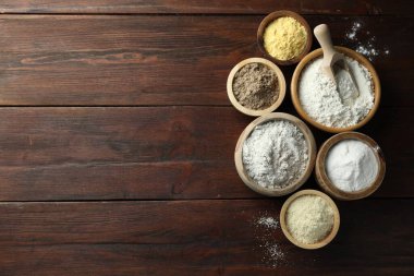 Tahta masadaki kaselerdeki farklı un türleri, düz yatış. Metin için boşluk