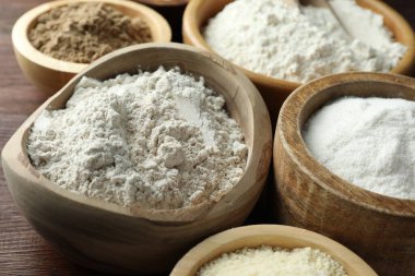 Tahta masadaki kaselerdeki farklı un türleri, yakın plan.