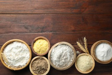 Tahta masadaki kaselerdeki farklı un türleri, düz yatış. Metin için boşluk