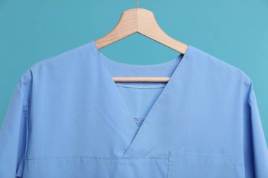 Tıbbi işçi üniforması mavi arka planda, yakın planda.