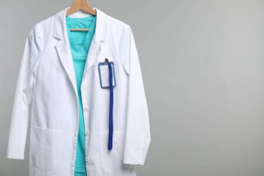 Gri arka planda askısı olan doktorun ceketi. Metin için boşluk