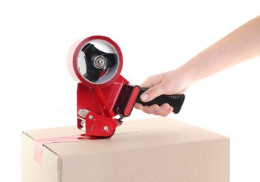 Kadın, beyaz arka plandaki karton kutuyu mühürlemek için yapışkan bantla yapıştırıcı kullanıyor.