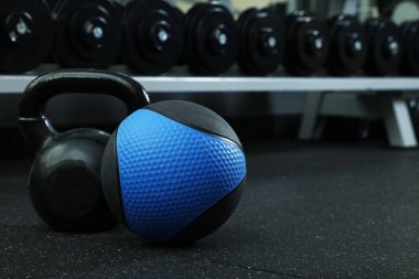 Spor salonunda yerde mavi ilaç topu ve kettlebell, metin için yer