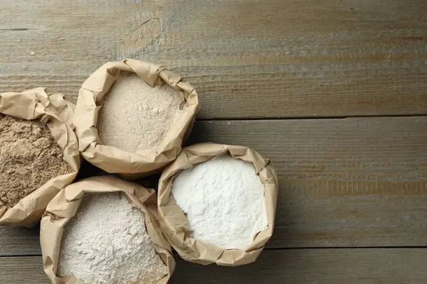 Tahta masadaki kağıt torbalarda farklı türde un var. Metin için boşluk