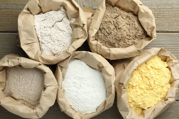 Tahta masadaki kağıt torbalarda farklı türde un var.