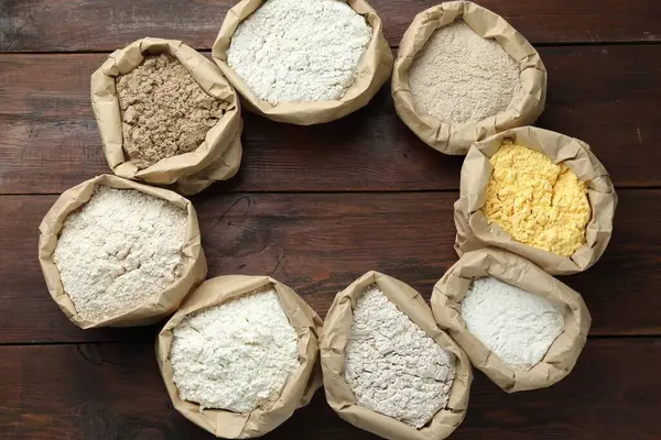 Tahta masada, düz bir zeminde, kağıt torbalarda farklı un türlerinden bir çerçeve. Metin için boşluk