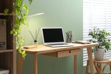 Merkez ofis. Oda odasındaki ahşap masada dizüstü bilgisayarı ve kırtasiyesi olan rahat bir iş yeri