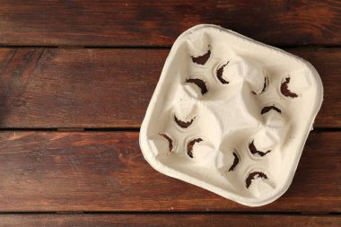 Empty cardboard cup holder on wooden table, top view. Space for text