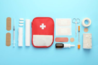 First aid kit. Different medical supplies on light blue background, flat lay