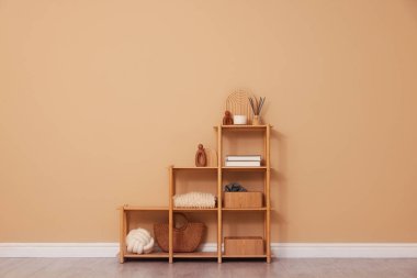 Shelving unit with decor near beige wall indoors