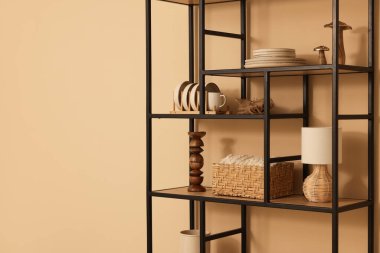 Shelving unit with decor near beige wall indoors, space for text