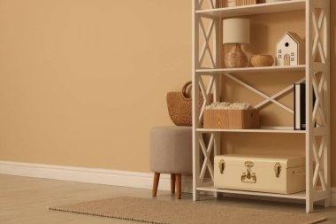 Dekor, dışkı ve hasır çantalı raf ünitesi, kapalı alanda bej duvar, metin için boşluk