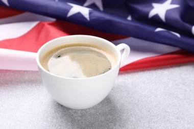 Bir fincan kahve ve Amerikan bayrağı açık masada, yakın plan.