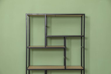 İçerideki zeytin duvarının yanındaki boş ahşap raf ünitesi.