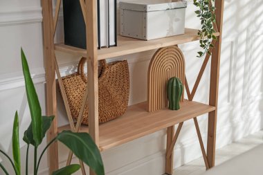 Beyaz duvarın yanında dekorasyonu olan şık raf ünitesi.