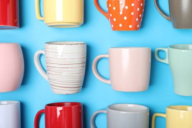 Açık mavi arkaplanda bir sürü renkli fincan, düz yatıyordu.