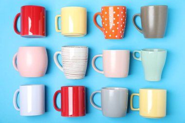 Açık mavi arkaplanda bir sürü renkli fincan, düz yatıyordu.