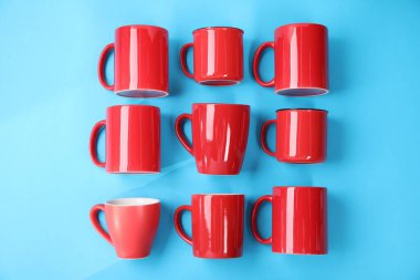 Açık mavi arkaplanda bir sürü kırmızı bardak, düz uzanmış.