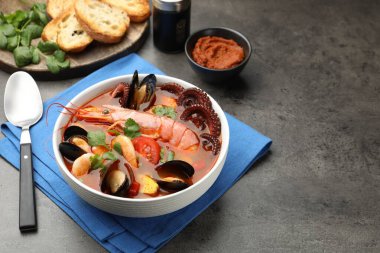 Gri dokulu masada servis edilen lezzetli deniz ürünleri çorbası.