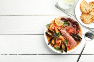 Beyaz ahşap masada servis edilen nefis deniz ürünleri çorbası. Metin için boşluk