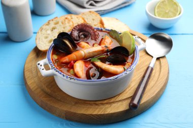 Lezzetli deniz ürünleri çorbası mavi ahşap masada, yakın plan.