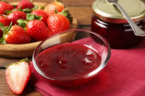 Lezzetli çilek sosu ve ahşap masada taze böğürtlen, yakın plan.