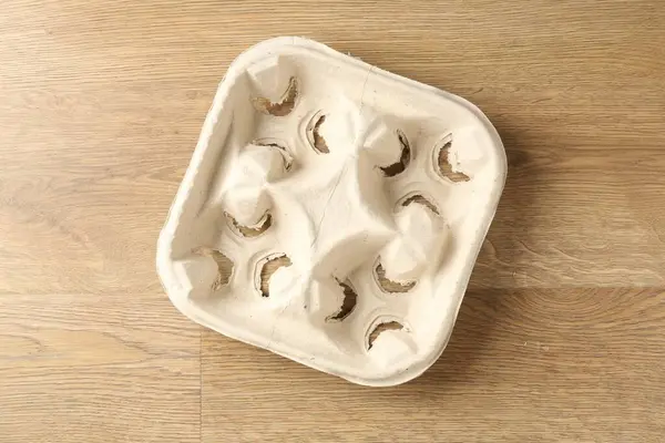 Boş mukavva bardak tutacağı ahşap masanın üstünde, üst görünümde.