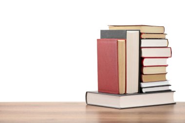 Beyaz arka plana karşı ahşap masada birçok eski kitap