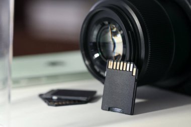 SD hafıza kartları ve fotoğraf makinesi beyaz masada, yakın plan.