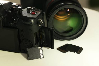SD hafıza kartları ve fotoğraf makineleri beyaz masada, yakın plan