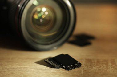 SD hafıza kartları ve fotoğraf makinesi ahşap masada, yakın plan.