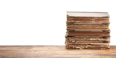 Tahta masadaki eski kitaplar beyaz arka plana karşıdır