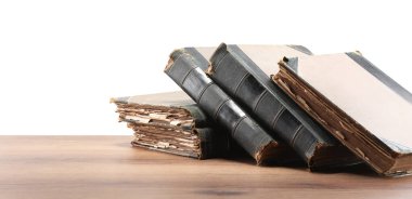 Tahta masadaki eski kitaplar beyaz arka plana karşıdır