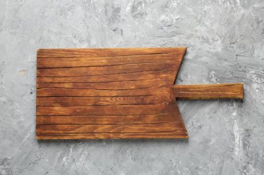 Açık gri desenli bir masada ahşap servis tahtası, üst manzara. Metin için boşluk