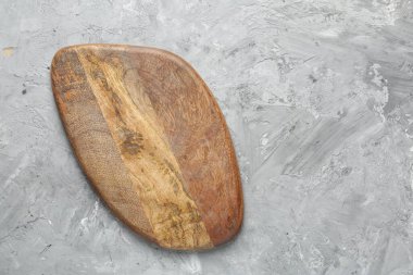 Açık gri desenli bir masada ahşap servis tahtası, üst manzara. Metin için boşluk