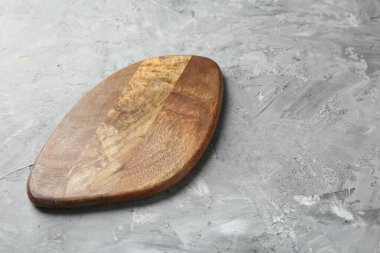 Açık gri desenli bir masada ahşap servis tahtası, yakın plan. Metin için boşluk