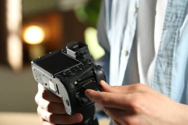 Bir adam fotoğraf makinesine SD bellek kartı yerleştiriyor.