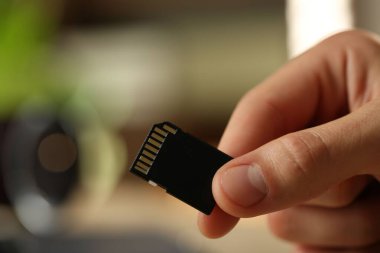 Bulanık arkaplanda SD hafıza kartı olan adam, yakın plan