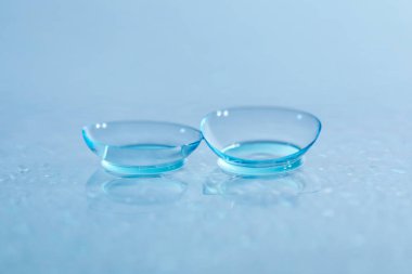 Ayna yüzeyine bir çift kontak lens ve su damlası, yakın plan.
