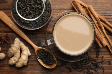 Fincanda Aromatik Masala çayı, ahşap masada baharatlar ve kuru yapraklar.