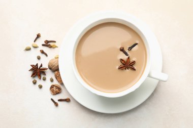 Fincanda Aromatik Masala çayı, açık gri masada kuru yapraklar ve baharatlar.