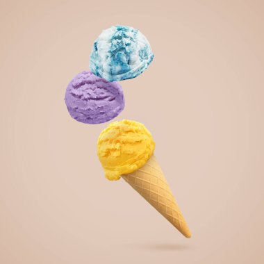 Dondurma kepçeleri ve koyu bej arka planda havada waffle külahı.