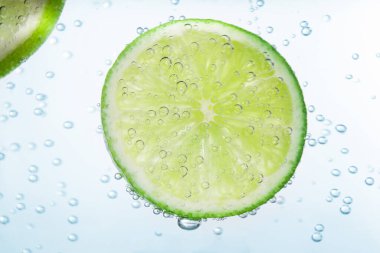 Beyaz arka planda limon dilimli soda, yakın plan.