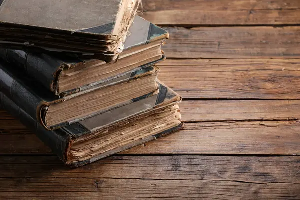 Ahşap masada bir sürü eski kitap, yakın plan. Metin için boşluk