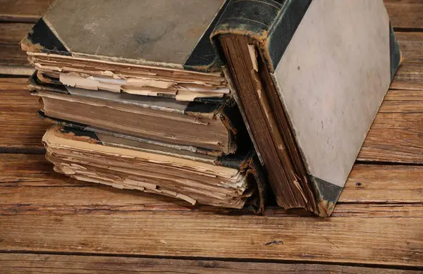 Ahşap masada bir sürü eski kitap, yakın plan.