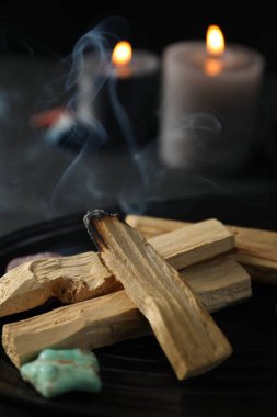 Yanan palo santo sopası, değerli taş ve yanan mumlar, yakın plan.