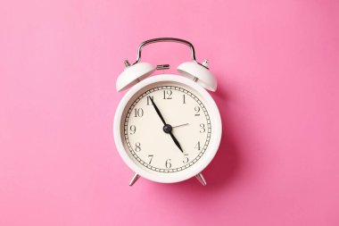 Pembe arka planda beyaz alarm saati, üst görünüm